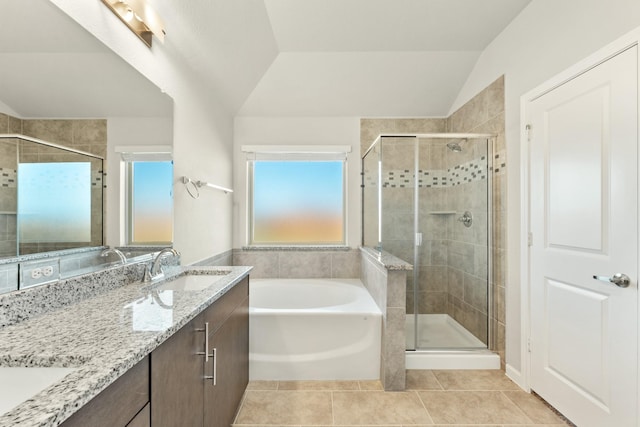 bathroom with tile patterned flooring, shower with separate bathtub, vanity, and lofted ceiling