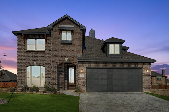 view of front of home with a garage and a yard