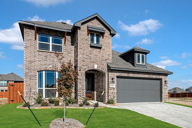 view of front of property featuring a front lawn and a garage