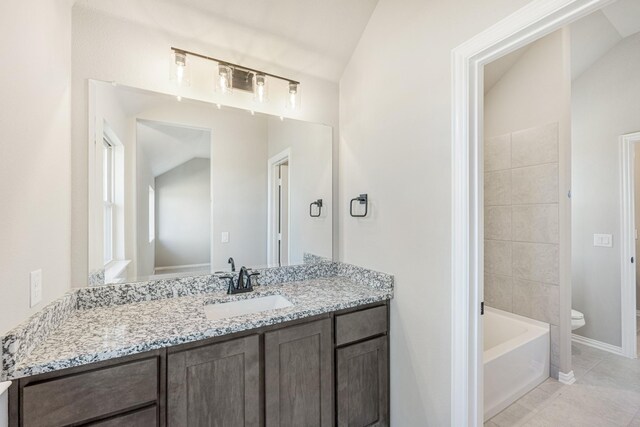 full bathroom featuring tile patterned flooring, vanity, toilet, and vaulted ceiling