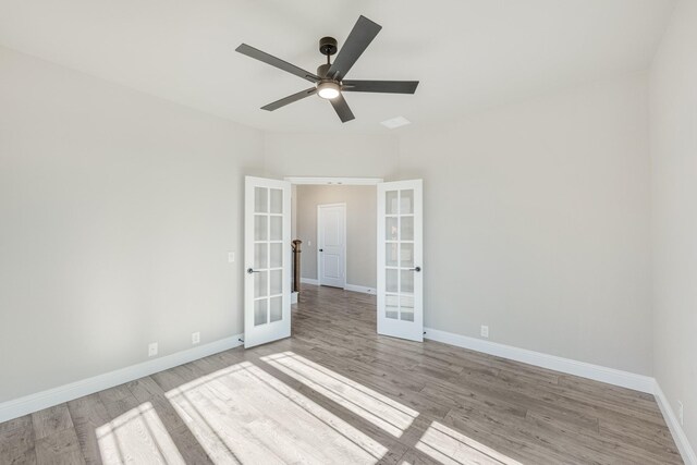 spare room featuring french doors, light wood-type flooring, and ceiling fan