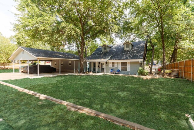 rear view of property with a lawn and a carport