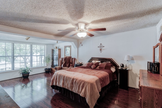 bedroom with ceiling fan, dark hardwood / wood-style flooring, and a textured ceiling