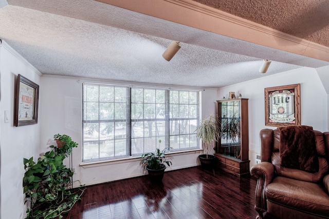 living area featuring dark hardwood / wood-style flooring, ornamental molding, ceiling fan, and a textured ceiling