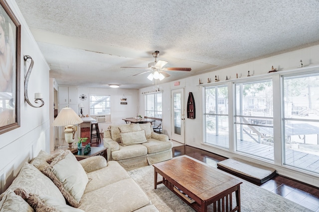 living room featuring plenty of natural light, ceiling fan, and a textured ceiling