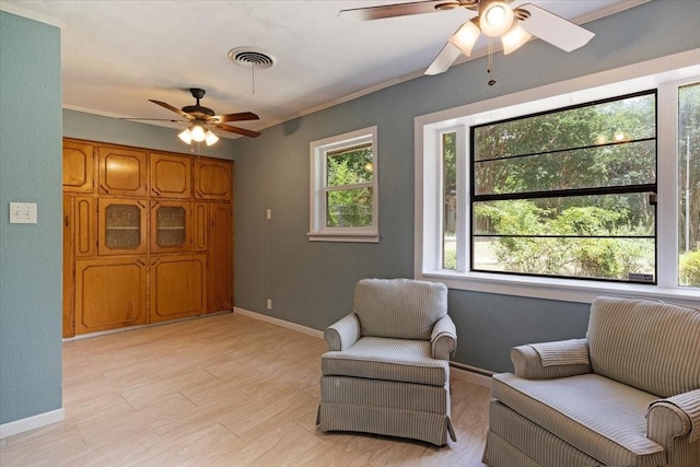 living area featuring ornamental molding and ceiling fan