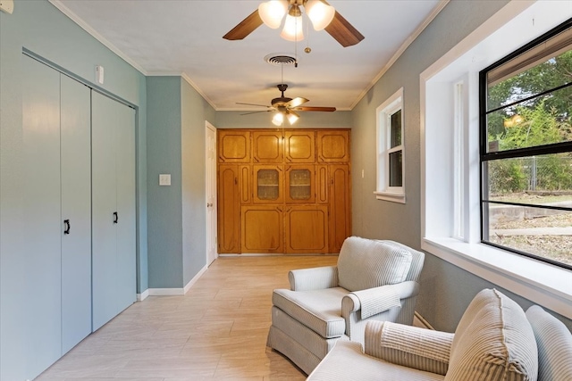 living area with ceiling fan and ornamental molding