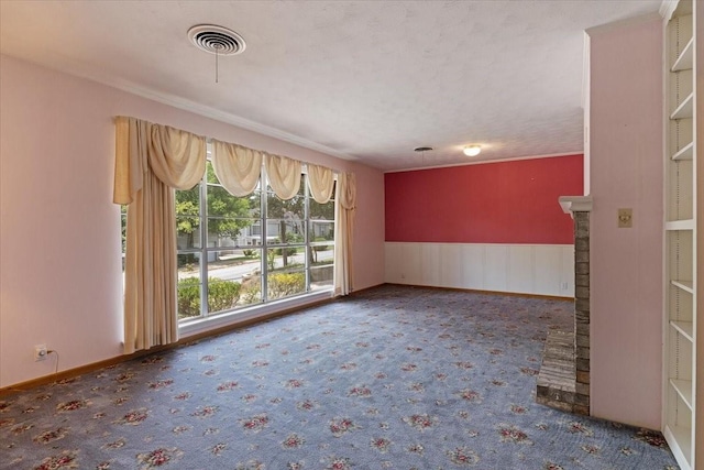 unfurnished room with a brick fireplace and a textured ceiling