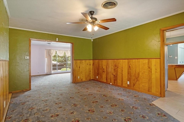 carpeted empty room featuring ceiling fan and ornamental molding