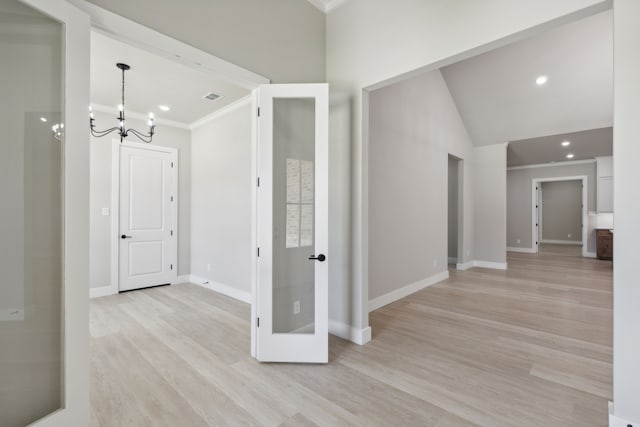 hall with crown molding, light hardwood / wood-style flooring, and an inviting chandelier