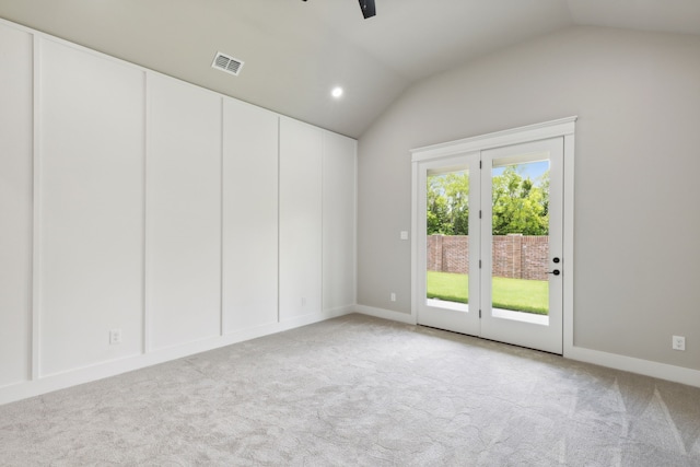 spare room featuring ceiling fan, light colored carpet, and lofted ceiling