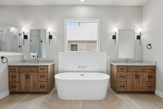 bathroom with hardwood / wood-style floors, vanity, and shower with separate bathtub