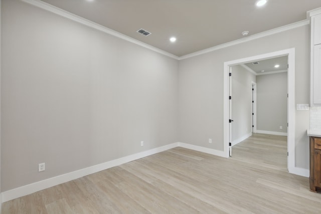 spare room featuring light hardwood / wood-style flooring and ornamental molding