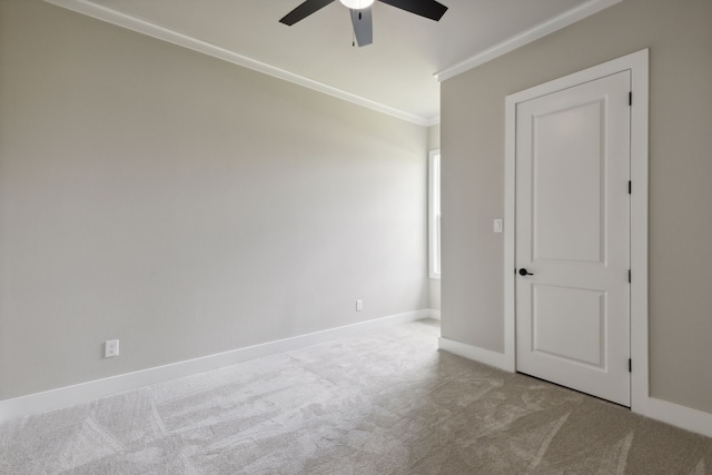 carpeted spare room with ceiling fan and ornamental molding