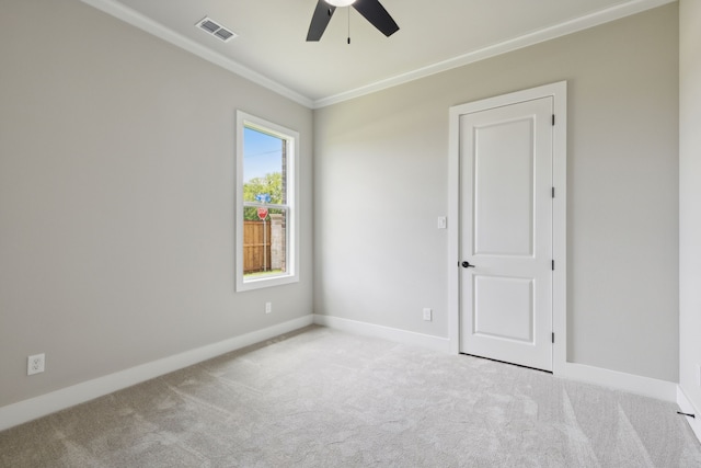 carpeted spare room featuring ceiling fan and ornamental molding