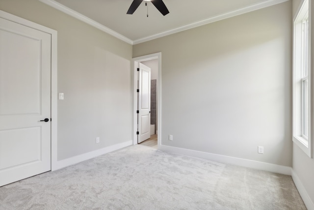 unfurnished room with light colored carpet, ceiling fan, and crown molding