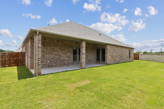 back of property featuring a lawn and a patio area