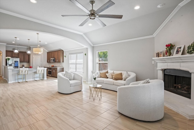 living room with lofted ceiling, ornamental molding, and ceiling fan