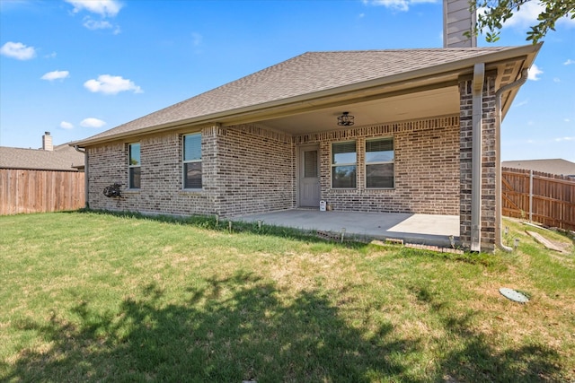 rear view of property featuring a patio area and a lawn