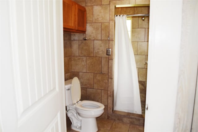 bathroom with curtained shower, tile patterned flooring, and toilet