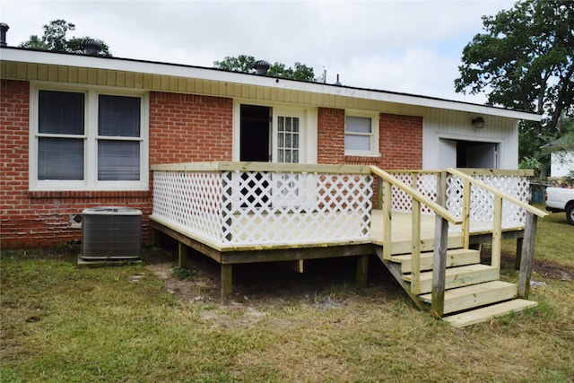 back of house featuring a lawn, a wooden deck, and central AC