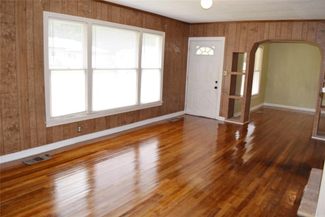 foyer entrance featuring hardwood / wood-style flooring and wooden walls