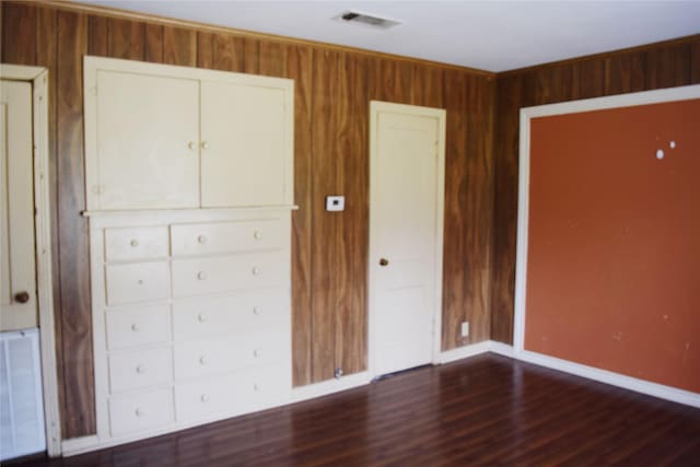 unfurnished bedroom featuring radiator and dark hardwood / wood-style flooring