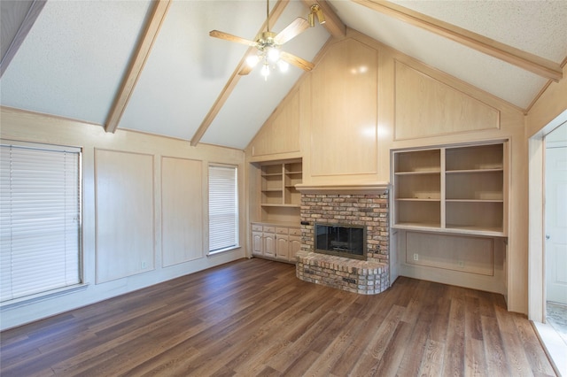 unfurnished living room featuring ceiling fan, lofted ceiling with beams, built in features, and a fireplace