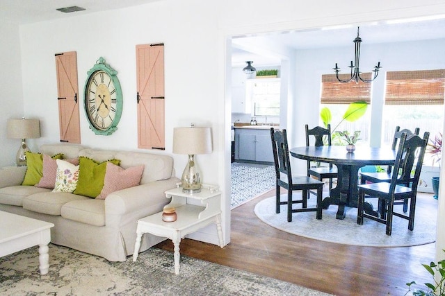 living room with wood-type flooring and a chandelier