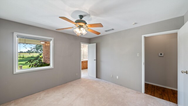 unfurnished bedroom featuring a spacious closet, wood-type flooring, and ceiling fan