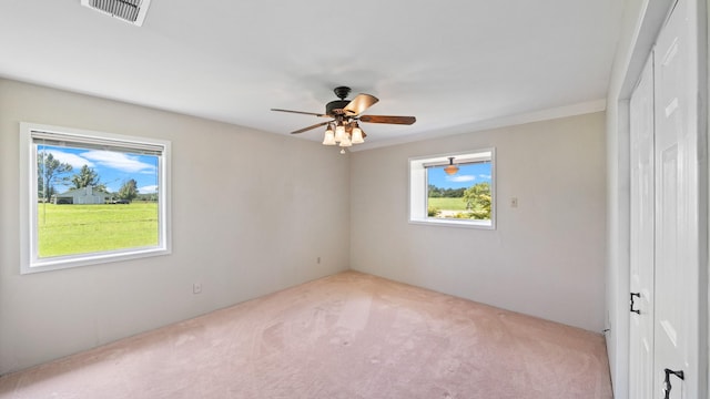 carpeted spare room with ceiling fan