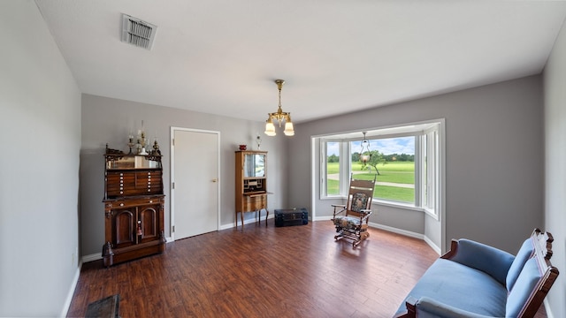 sitting room featuring dark wood-type flooring and a chandelier