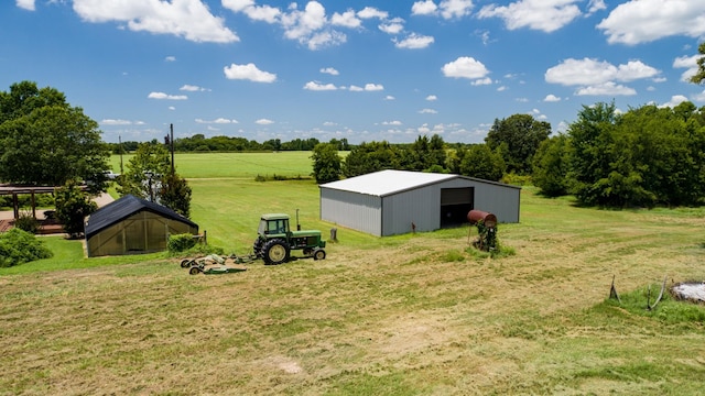 view of yard with an outdoor structure and a rural view