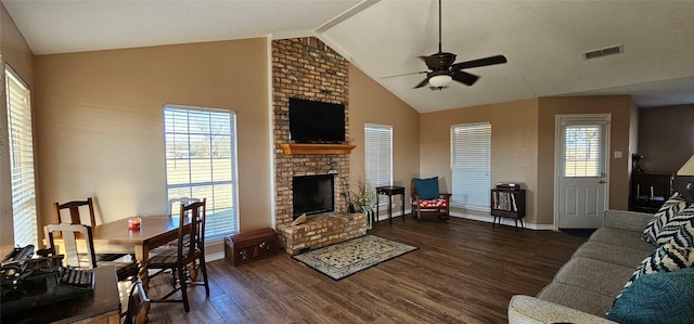 living room featuring ceiling fan, plenty of natural light, a fireplace, and dark hardwood / wood-style flooring