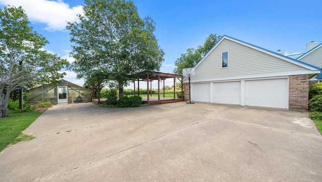 view of side of property featuring a garage and a pergola