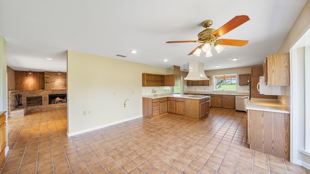 kitchen featuring custom exhaust hood, a brick fireplace, light tile patterned floors, stainless steel dishwasher, and ceiling fan