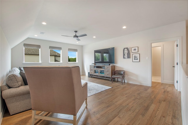 living room with hardwood / wood-style floors, ceiling fan, and lofted ceiling