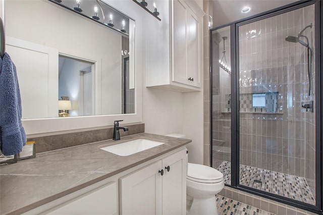 bathroom with tile patterned flooring, toilet, vanity, and walk in shower