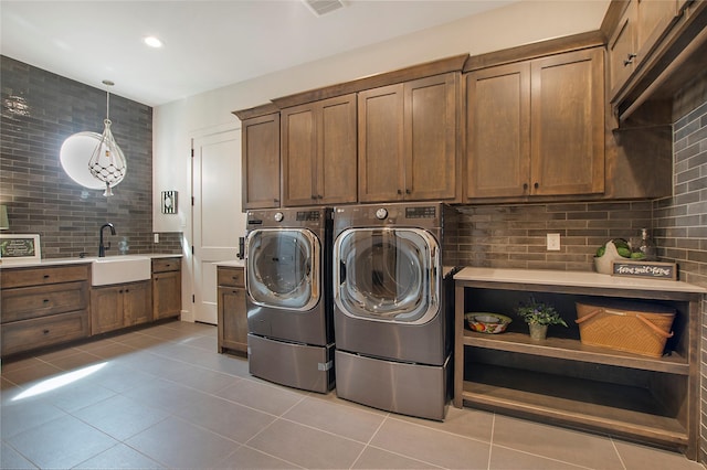 washroom with washer and clothes dryer, cabinets, light tile patterned floors, and sink