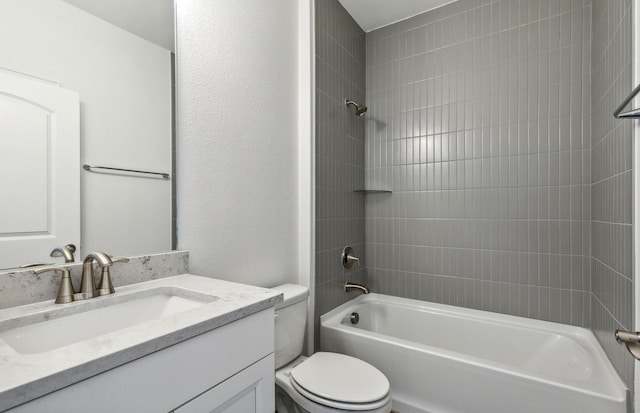 full bathroom with tiled shower / bath, vanity, and toilet