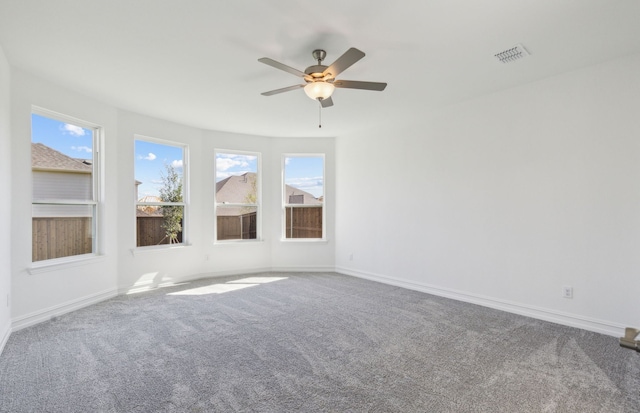 spare room featuring ceiling fan, plenty of natural light, and carpet floors