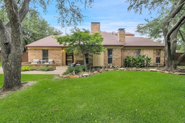 back of property with a patio and a lawn