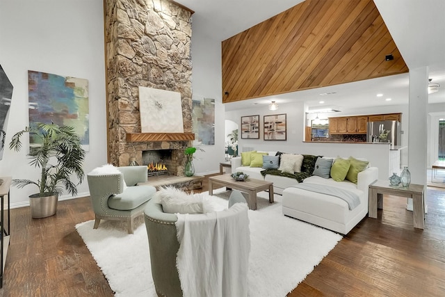 living room featuring dark hardwood / wood-style floors, a towering ceiling, and a fireplace