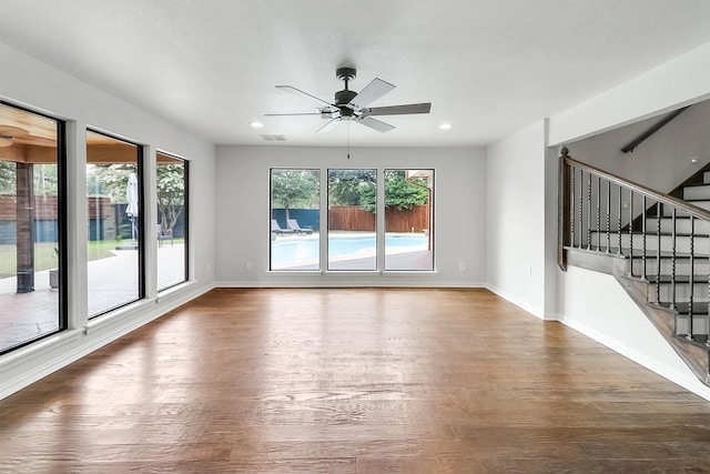 unfurnished living room featuring ceiling fan and dark hardwood / wood-style flooring