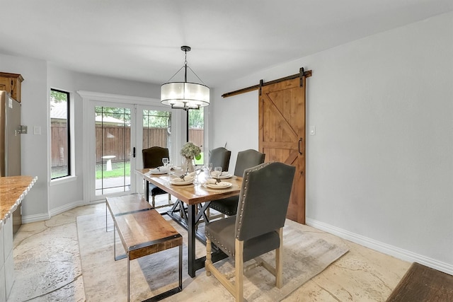 dining space with a barn door and french doors