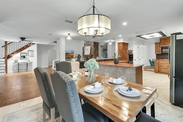 dining area with ceiling fan with notable chandelier