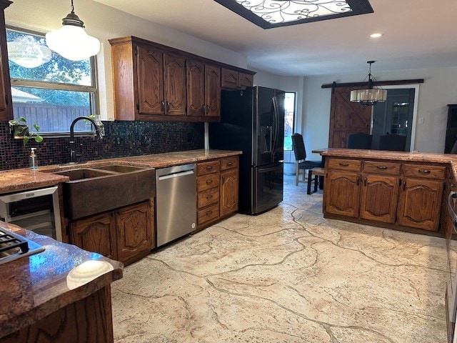 kitchen with dishwasher, a barn door, black refrigerator with ice dispenser, decorative light fixtures, and decorative backsplash