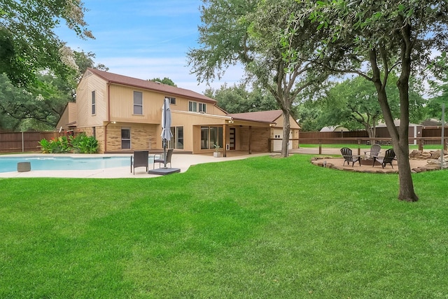 back of house with a fenced in pool, a lawn, and a patio