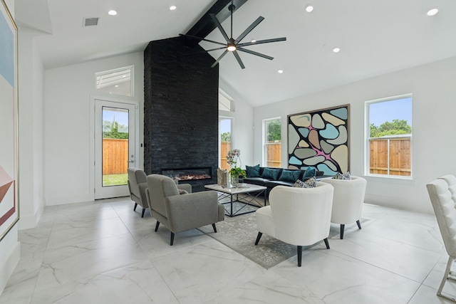 living room featuring a fireplace, beam ceiling, ceiling fan, and a healthy amount of sunlight