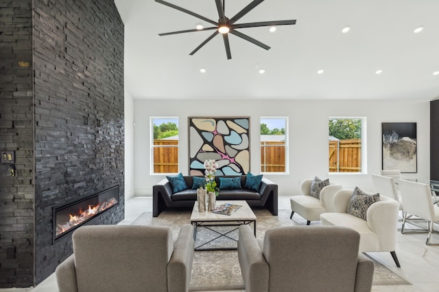 living room featuring a stone fireplace and ceiling fan